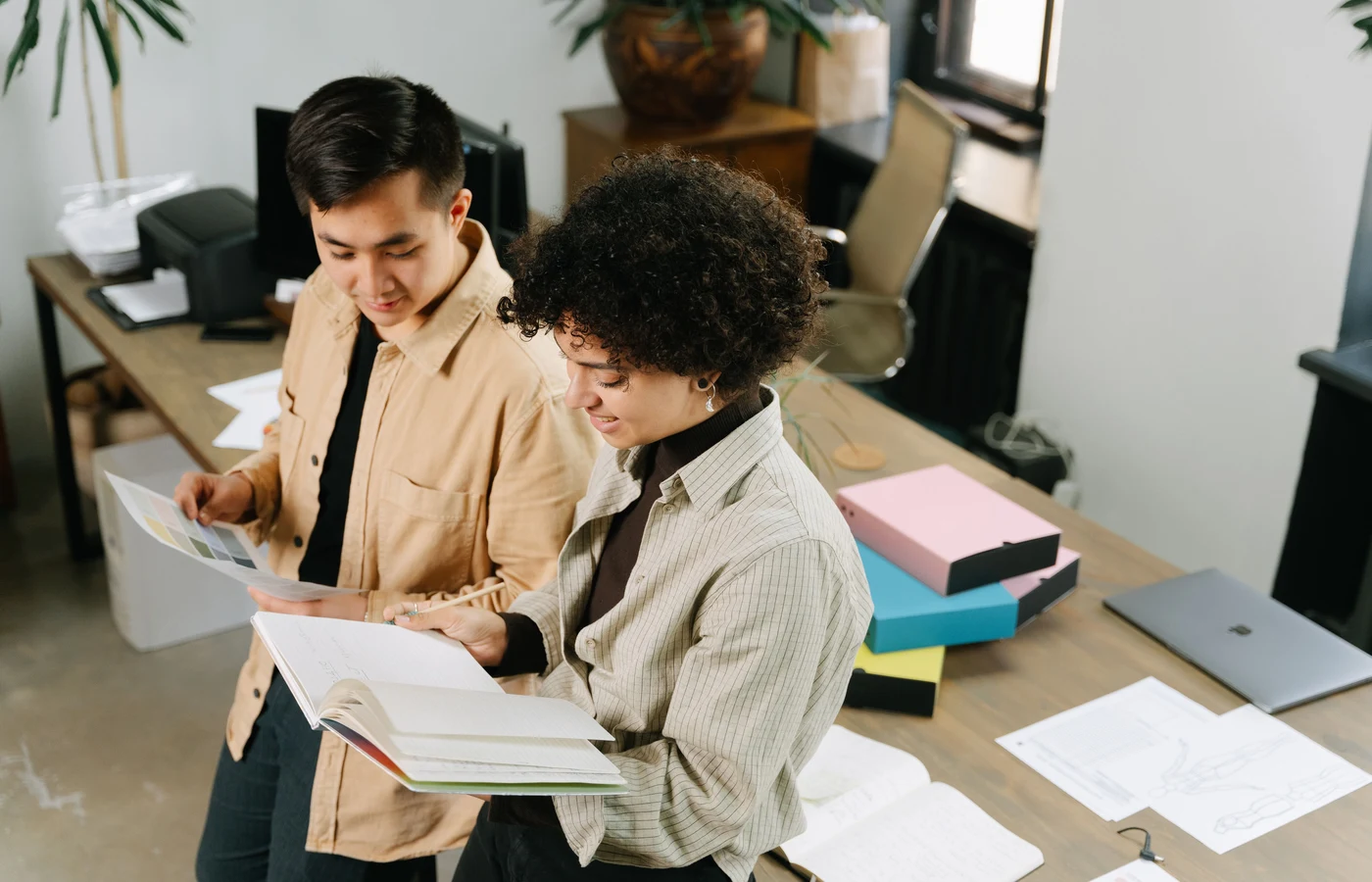 Deux collègues planifiant leurs prochaines actions avec des notes de travail